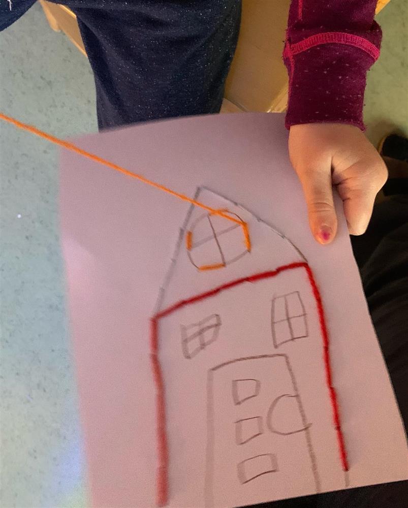 Barn som syr på teikna bilde av eit hus  - Klikk for stort bilete